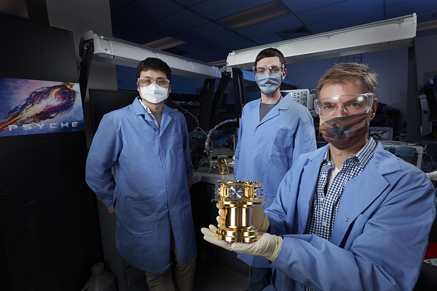Team members holding a gamma-ray spectrometer